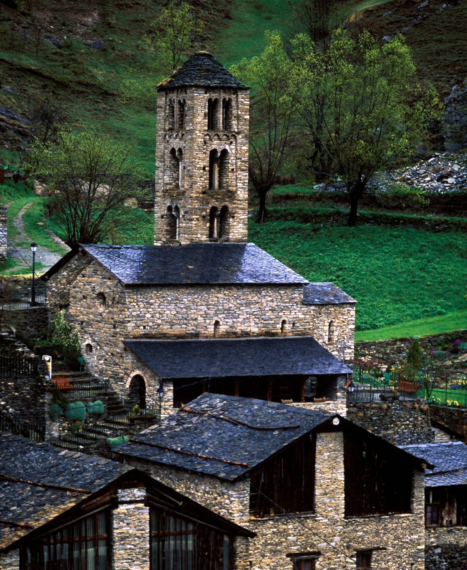 Sant Climent de Pal vist des de l'exterior envoltada de cases i prats.