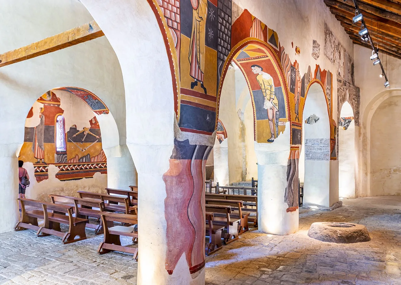 Interior de l'església de Sant Joan de Boí amb les pintures murals per les seves parets. 