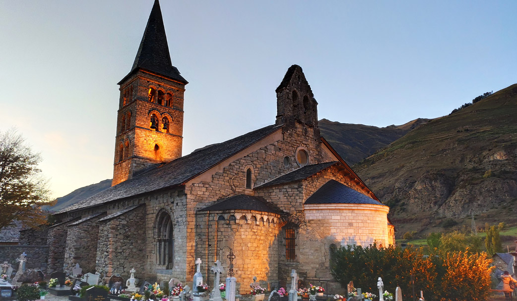 Vista exterior de l'església de Santa Maria d'Arties il·luminada, amb el cementiri. 
