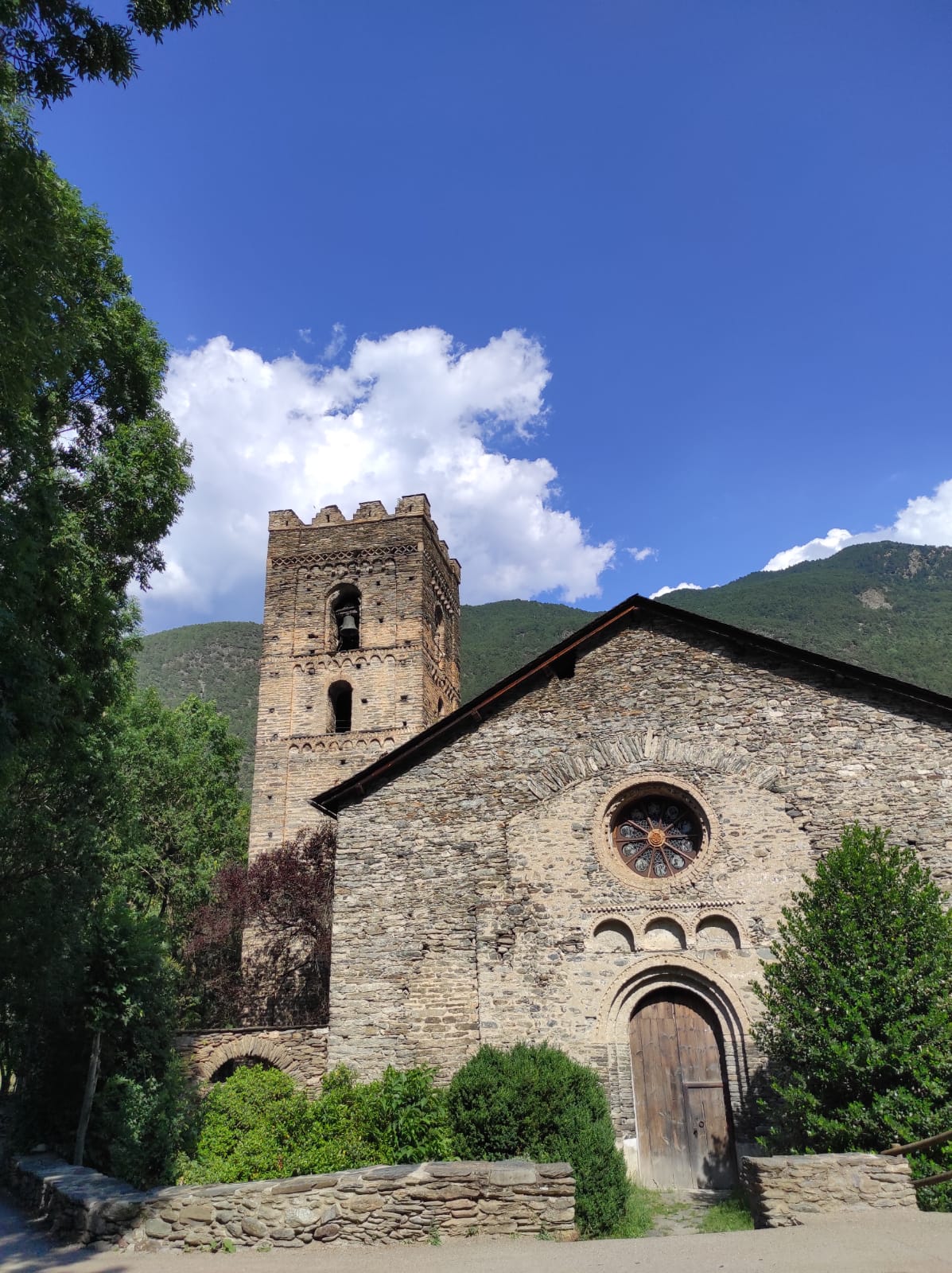 Vista exterior de l'església de Santa Maria de Ribera de Cardós amb el seu campanar de merlets.