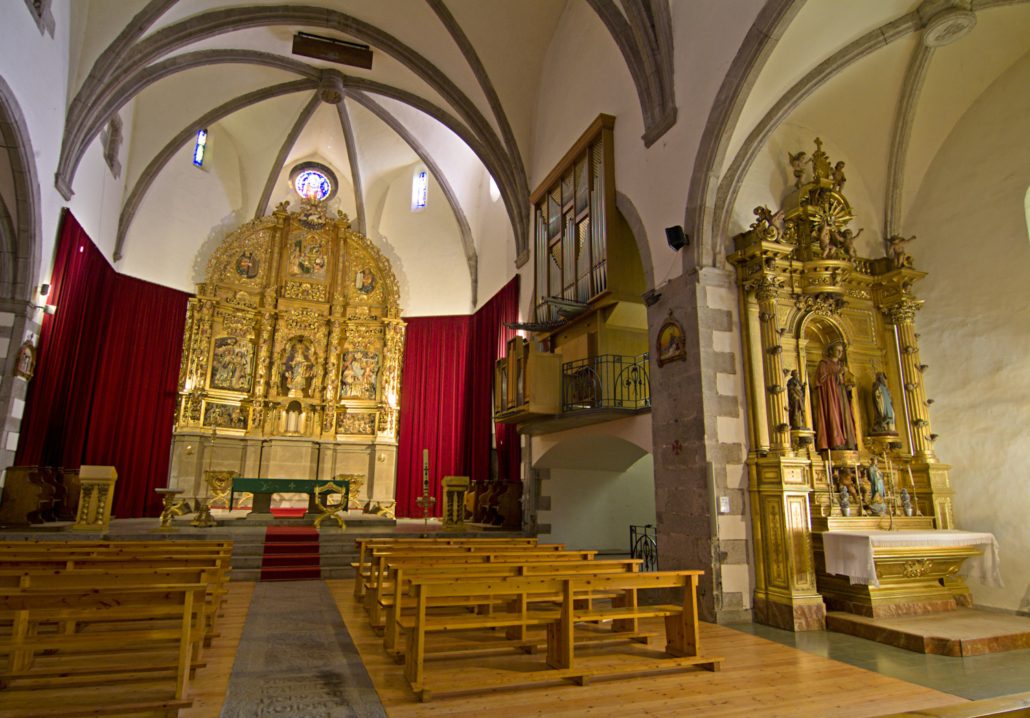 Vista interior de l'església de la Mare de Déu dels Àngels de Llívia amb el retaule barroc que presideix l'església. 