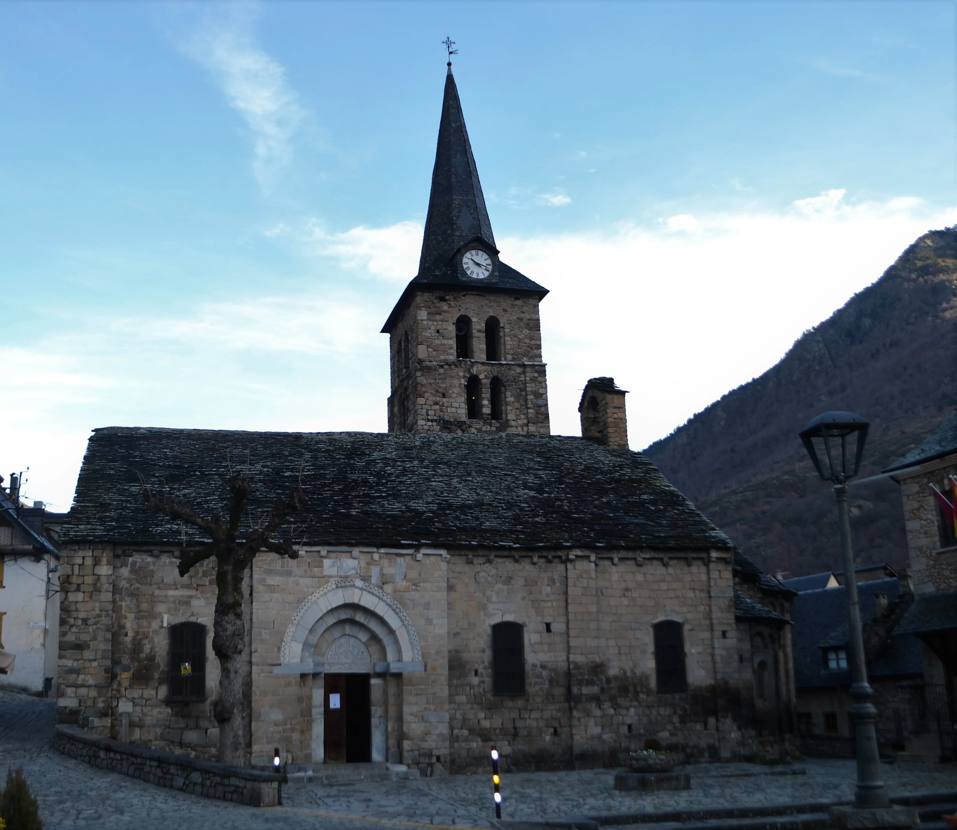 Vista exterior de l'església de la Mair de Diu dera Purificacion de Bossost. Sobresurt el seu campanar de torre amb un rellotge. 