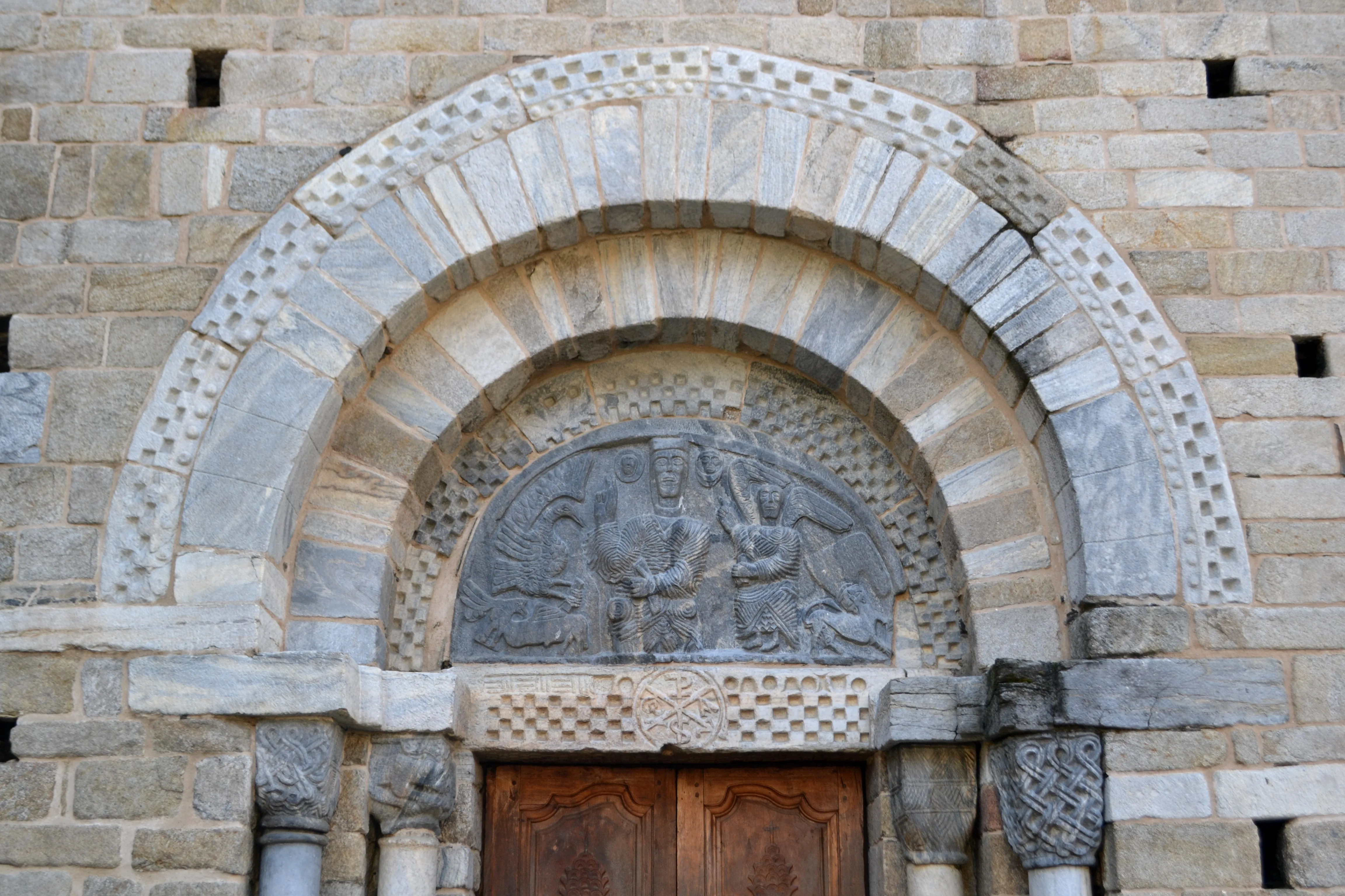 Portalada exterior de l'església de Mair de Diu dera Purificacion de Bossost. És una portalada en pedra molt treballada.