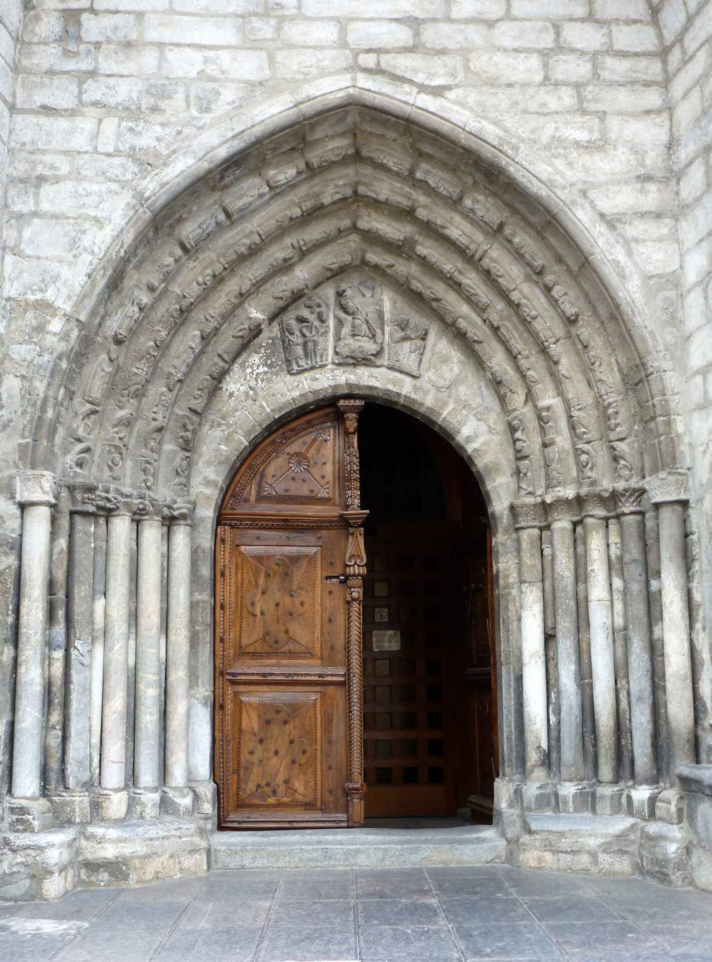 Imatge de la portalada principal de l'església de Sant Miquèu de Vielha. Una portalada treballada en pedra amb 6 arcs.